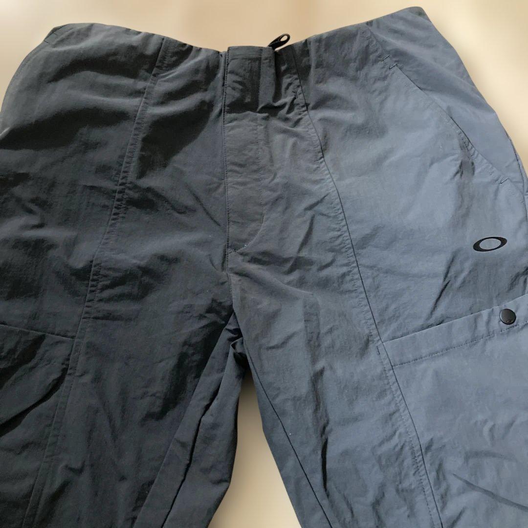 新品未使用タグ付きOAKLEYマットチャコールグレーピステウィンドブレーカーXL