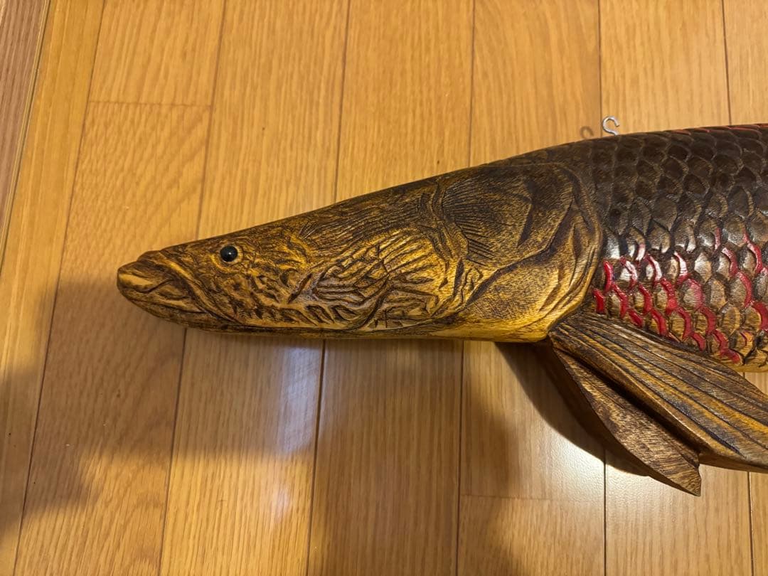 ピラルクの木製彫刻 赤と金の鱗模様