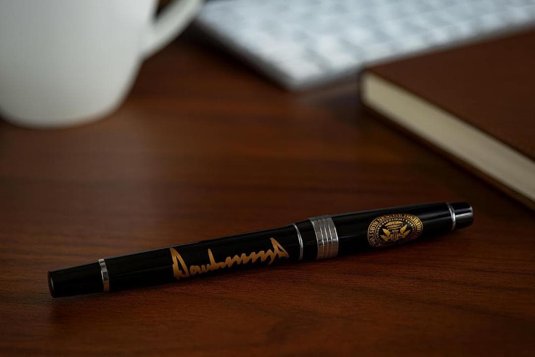 ドナルド・トランプ大統領の署名ペン。黒のボールペン 金色サイン付き